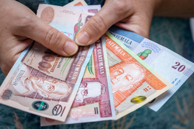 Photo of woman holding Guatemalan Quetzal banknotes