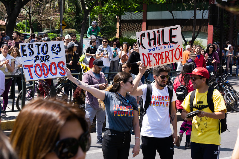 Chilean protesters on the street in 2019 holding signs that say "Chile despertó"